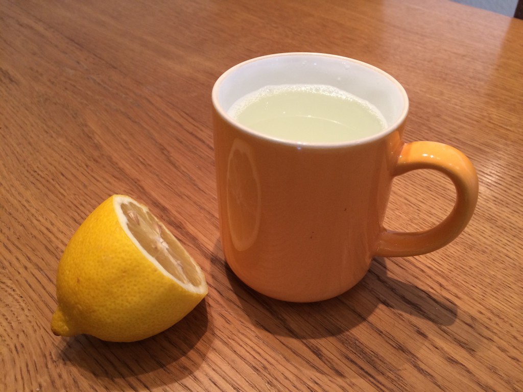 Zitronen Tee in Teetasse mit halber Zitrone garniert